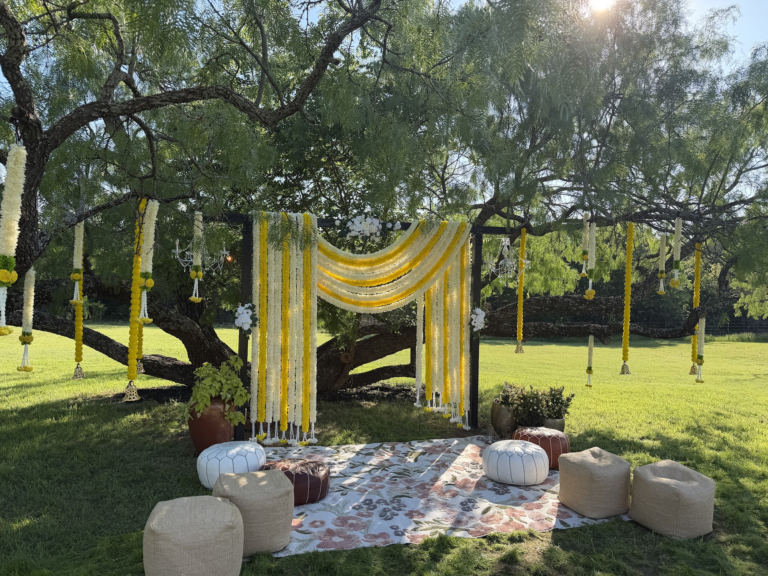 Yellow and ivory floral garlands with garden lounge seating in daylight